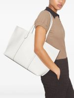 White bag carried by a person, showing the bag’s fit