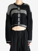 Black knitwear worn by a person, showing the knitwear fit